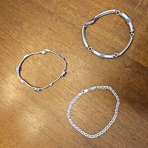 Three silver-toned bracelets - at least one is sterling silver